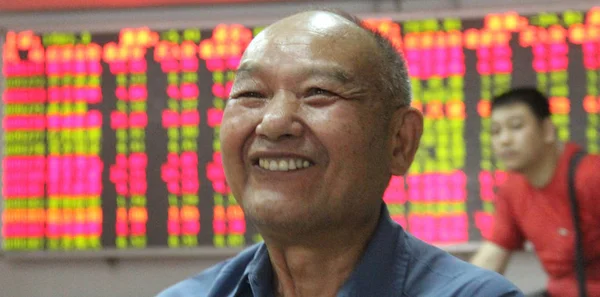 Китайський Інвестор Посміхається Щасливо Після Перевірки Цін Акцій Червоний Зростання — стокове фото
