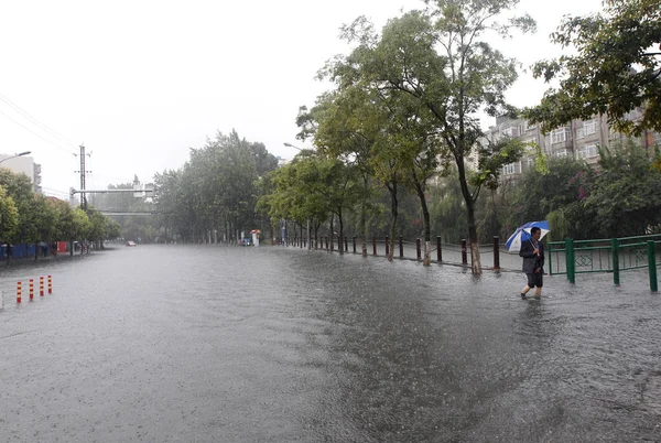 Pieszy Przechodzi Ulicy Zalane Podczas Ulewnego Deszczu Kunming Południowo Zachodniej — Zdjęcie stockowe