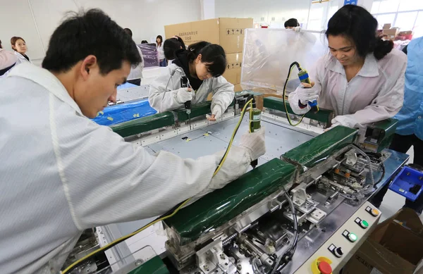 中国の労働者は 2014年3月25日 中国中央省湖南省河陽市のフォックスコン テクノロジー グループが所有するホン フジン精密工業 Hengyang 社の工場で Letvのスマートテレビセットを組み立てます — ストック写真