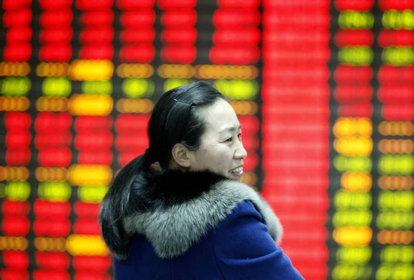 Китайський Інвесторів Посміхається Перед Екраном Відображення Цін Акцій Червоний Зростання — стокове фото