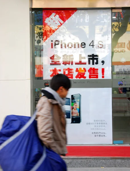 2012年1月13日 在中国东部江苏省淮安市的一家商店 一位行人走过苹果Iphone 4S智能手机的广告海报 — 图库照片