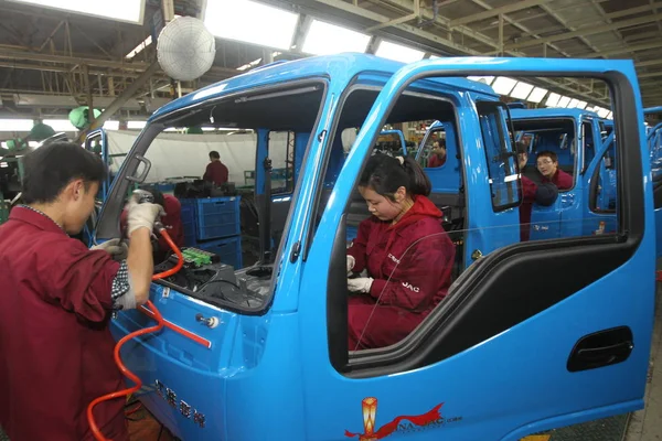 2014年3月15日 中国東部安寧省合肥市にある安寧江華汽車有し自動車 Jac の自動車工場で 中国人労働者が組み立てラインにトラックを組み立てる — ストック写真