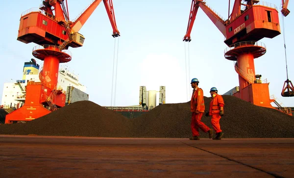 中国の労働者は 中国東部の山東省Rizhao市のRizhao港の岸壁に輸入された鉄のオレの山を通り過ぎる 2014年7月3日 — ストック写真