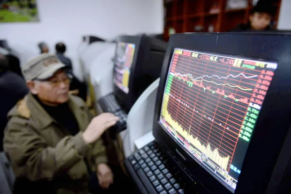 2014年12月4日 中国投资者在中国东部山东省青岛市一家股票经纪公司观看显示股价和上证综指的电脑显示屏 — 图库照片