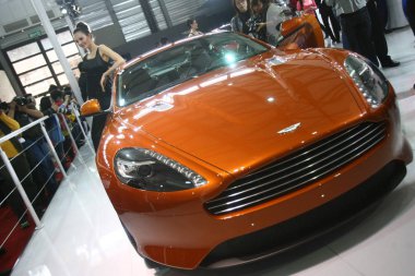 Visitors look at an Aston Martin sports car during an auto show in Shanghai, China, 19 April 2011 clipart