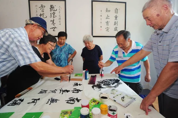 地元の高齢者が中国の書道を書き 中国浙江省東部のハイディングのコミュニティセンターで中国の絵画を描く 2013年8月8日 — ストック写真