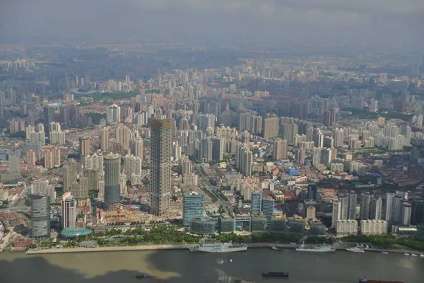 This picture taken from high in the Shanghai Tower under construction in Pudong shows a view of Huangpu River and Puxi with high-rise buildings and residential buildings in Shanghai, China, 30 August 2014.