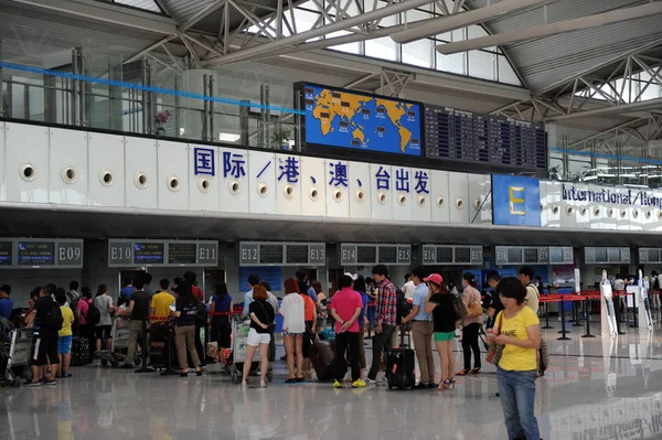 乗客は 2013 日東中国山東省青島に青島空港の出発ラウンジでチェックインに並ぶ — ストック写真