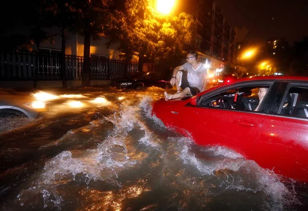 Een Man Zit Een Motorkap Van Een Auto Een Overstroomde — Stockfoto