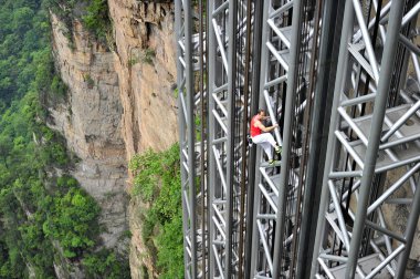 French climber Jean-Michel Casanova climbs the Bailong Elevator, also known as the Hundred Dragons Elevator, in Zhangjiajie scenic spot in central Chinas Hunan province, 18 May 2013 clipart