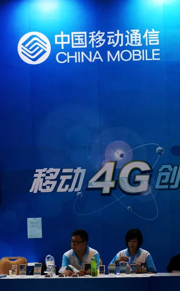 従業員は 中国天津 2013年9月14日の展示会中に中国モバイルのスタンドで見られます — ストック写真