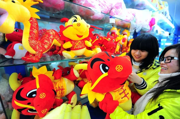 中国の女の子は 2012年1月4日 中国東部江蘇省陽州市の店でおもちゃのドラゴンを買い物します — ストック写真