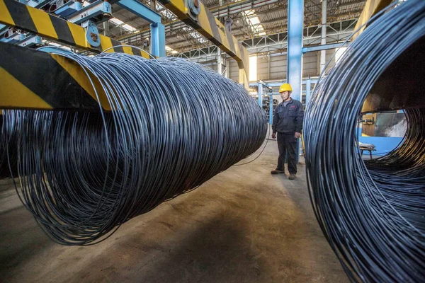 2014年10月11日 在中国东部江苏省连云港市一家钢铁厂 一名中国工人正在观看被吊起的钢筋卷 — 图库照片