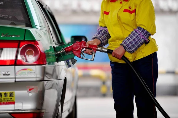 従業員は 2014年4月24日 中国河南省中部のLuoyang市のガソリンスタンドで車に燃料を補給します — ストック写真
