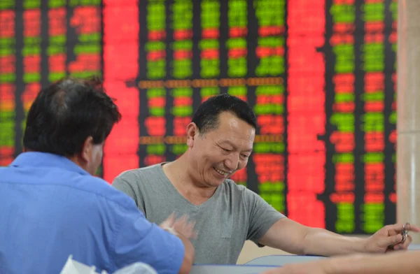 Два Китайских Инвестора Счастливо Разговаривают Проверяя Цены Акции Зеленые Падение — стоковое фото