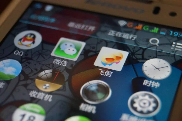 2014年8月4日 在中国中部河南省郑州市 一位中国手机用户通过智能手机查看腾讯 Wechat 和中国移动 Fetion 的手机短信应用Qq的图标 — 图库照片