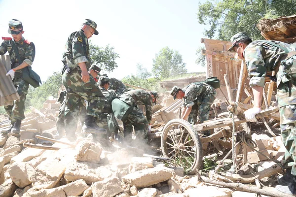 中国の救助隊は 2013年7月22日 中国北西部の寧西市 寧西市ヘトゥオ村でマグニチュード6 6の地震で壊滅的な被害を受けた家屋の残骸の中で生存者と犠牲者を捜索します — ストック写真