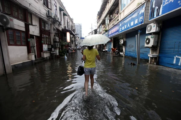 2013年9月13日 中国上海 一位中国妇女因倾盆大雨而走在被洪水淹没的街道上 — 图库照片