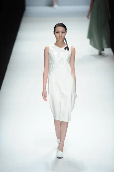 モデルは 2014 中国の北京で中国ロンドンファッションウィークの春 2015 年の間に Lianvis 連恵慶のファッションショーでリアン恵慶デザイナーによって新しい創造を表示します — ストック写真