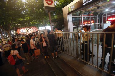 Chinese citizens queue up outside a subway station after three downtown districts of Shanghai were hit by a power outage that lasted about one-and-a-half hours in Shanghai, China, 5 June 2013 clipart