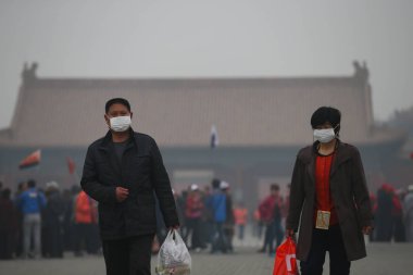 Tourists wearing face masks visit the Forbidden City in heavy smog in Beijing, China, 27 March 2014 clipart