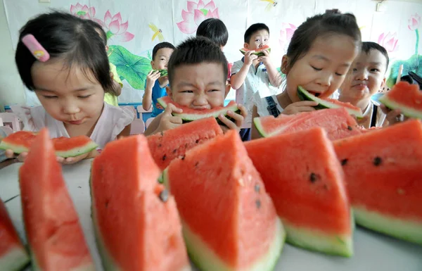 stock image Chinese kids eat watermelons to mark Liqiu, or the Beginning of Autumn on the Chinese lunar calendar, at a kindergarten in Handan city, north Chinas Hebei province, 7 August 2014