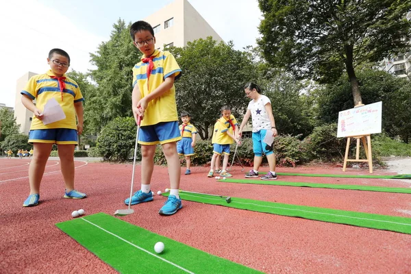 若い中国人留学生でゴルフをプレー遊び場で杭州日小学校で新学期の最初の日に 2014 日中国東部の浙江省杭州市 — ストック写真