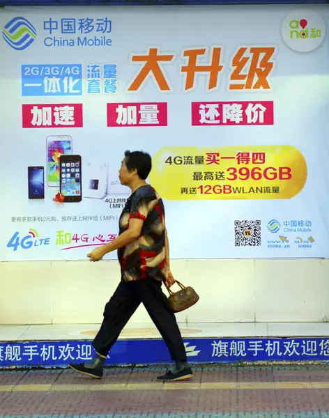 2014년 19일 후베이성 이창시에서 차이나 모바일 서비스 광고를 지나걷는 보행자 — 스톡 사진