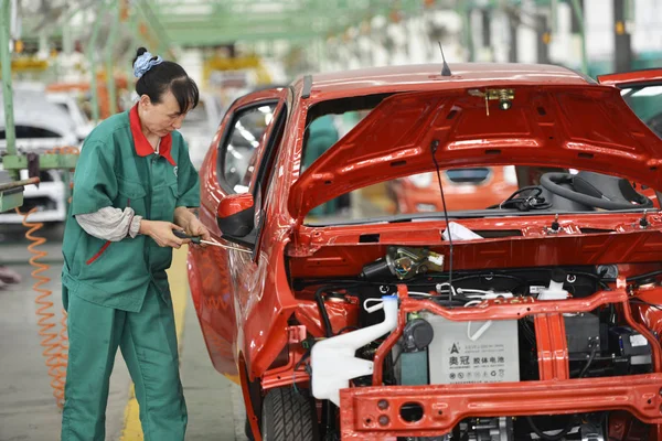 2014年7月16日 中国東部山東省ビンゾウ郡の山東ウィド新エネルギー自動車有し自動車の自動車工場で 中国人女性労働者が組み立てラインに電気自動車を組み立てる — ストック写真