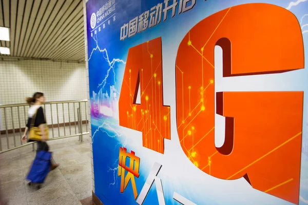 歩行者は 中国の地下鉄駅で中国モバイル4Gネットワークの広告を通り過ぎる 2013年5月25日 — ストック写真