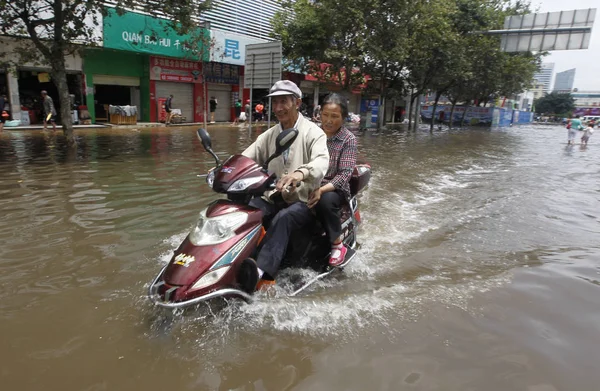中国自行车运动员在中国西南云南省昆明市一条公路上遭遇暴雨引发的勇敢洪水 2013年7月19日 — 图库照片