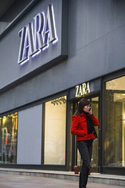 2012년 12월 26일 상하이의 스페인 브랜드 Zara 매장을 지나걷던 보행자가 — 스톡 사진