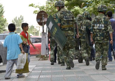 Chinese paramilitary policemen patrol a street in Kashgar city, northwest Chinas Xinjiang Uygur Autonomous Region, 23 July 2014 clipart