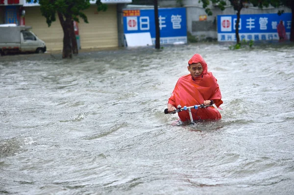 Rowerzysta Jeździ Zalanych Drogach Spowodowanych Przez Ulewne Deszcze Typhoon Kalmaegi — Zdjęcie stockowe