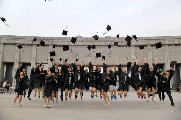 Chińskich Absolwentów Ubranych Akademickich Suknie Rzucać Kapelusze Powietrze Aby Świętować — Zdjęcie stockowe