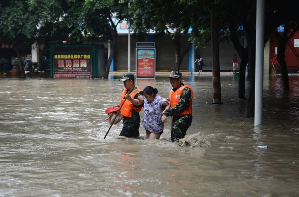 2013年7月11日 中国西南部四川省成都市金塘县 中国救援人员帮助一名当地居民在暴雨引发的洪水街道上行走 — 图库照片