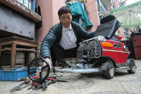 60岁的徐志云于2014年11月29日在中国上海组装微型车 — 图库照片