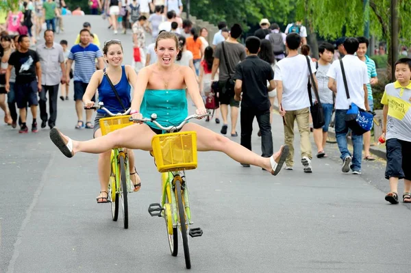 2013年7月20日 两名外国游客骑自行车游览中国东部浙江省杭州市西湖 — 图库照片