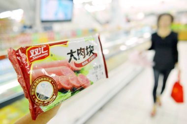 A customer buys Shineway sausage of Shuanghui Group, now called WH Group, at a supermarket in Hangzhou city, east Chinas Zhejiang province, 25 September 2013 clipart