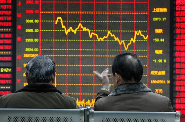 2014年12月24日 两名中国投资者在中国东部安徽省淮北市一家股票经纪公司查看股价和上证综指时进行了交谈 — 图库照片