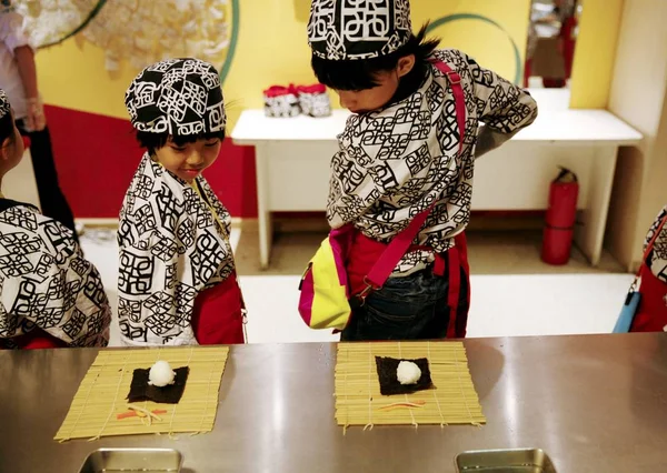 日本の料理の制服を着た若い子供たちは 2014年10月2日 北京の子供の職業博物館で寿司を作ることを学ぶ — ストック写真