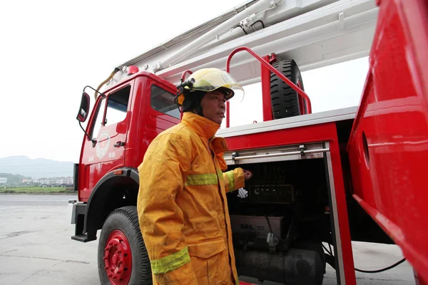 中国人実業家の李Lixing氏は 杭州小山ジンリプ ガーメント社のゼネラルマネージャーであり ジンリプー消防署のキャプテンを務め 浦陽町の消防署で消防車を操作している — ストック写真