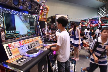Young kids play electronic video games during the 9th China International Cartoon and Games Expo, known as CCG Expo 2013, in Shanghai, China, 11 July 2013 clipart