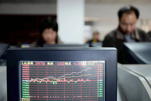 2014年12月4日 中国投资者在中国东部山东省青岛市一家股票经纪公司观看显示股价和上证综指的电脑显示屏 — 图库照片