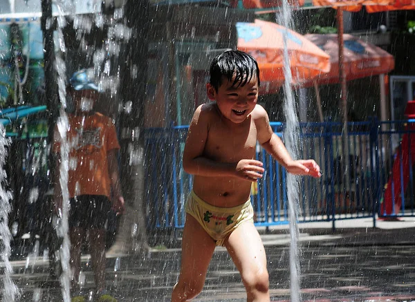 2013年7月24日 在中国东部浙江省杭州市 一个小男孩在炎热的天在喷泉里玩水降温 — 图库照片