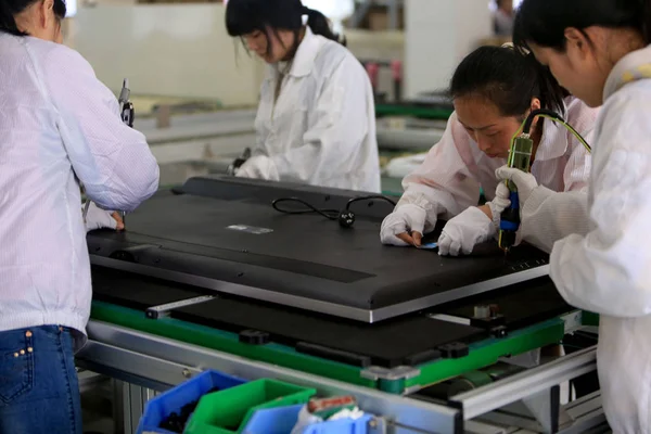 2014年3月25日 中国中部湖南省河陽市のフォックスコン テクノロジー グループが所有するホン フジン精密工業 Hengyang 社の工場で 中国人女性労働者がレトブのスマートテレビセットを組み立てる — ストック写真