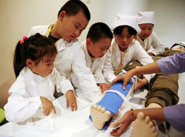 医師や看護師の制服に身を包んだ若い子供は 子供の職業博物館で応急処置スキルを学ぶ 2014 — ストック写真