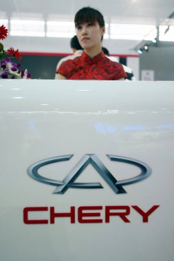 A Chinese employee looks on at the stand of Chery during the China International Industry Fair 2011 in Shanghai, China, 1 November 2011 clipart