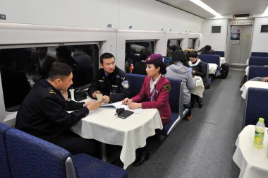 Crew members of CRH (China Railway High-speed) bullet train have a discussion about their works on the Beijing-Shanghai High-speed Railway, 7 February 2013 clipart