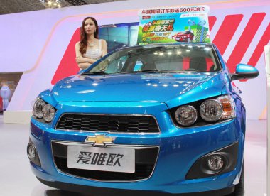 A model poses with a Chevrolet Aveo of Shanghai GM, a joint venture between SAIC and General Motors, during an automobile exhibition in Haikou city, south Chinas Hainan province, 22 April 2014 clipart
